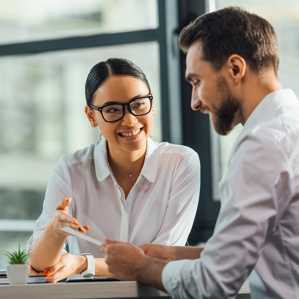 Two funeral professionals in an office setting, engaging in a discussion.